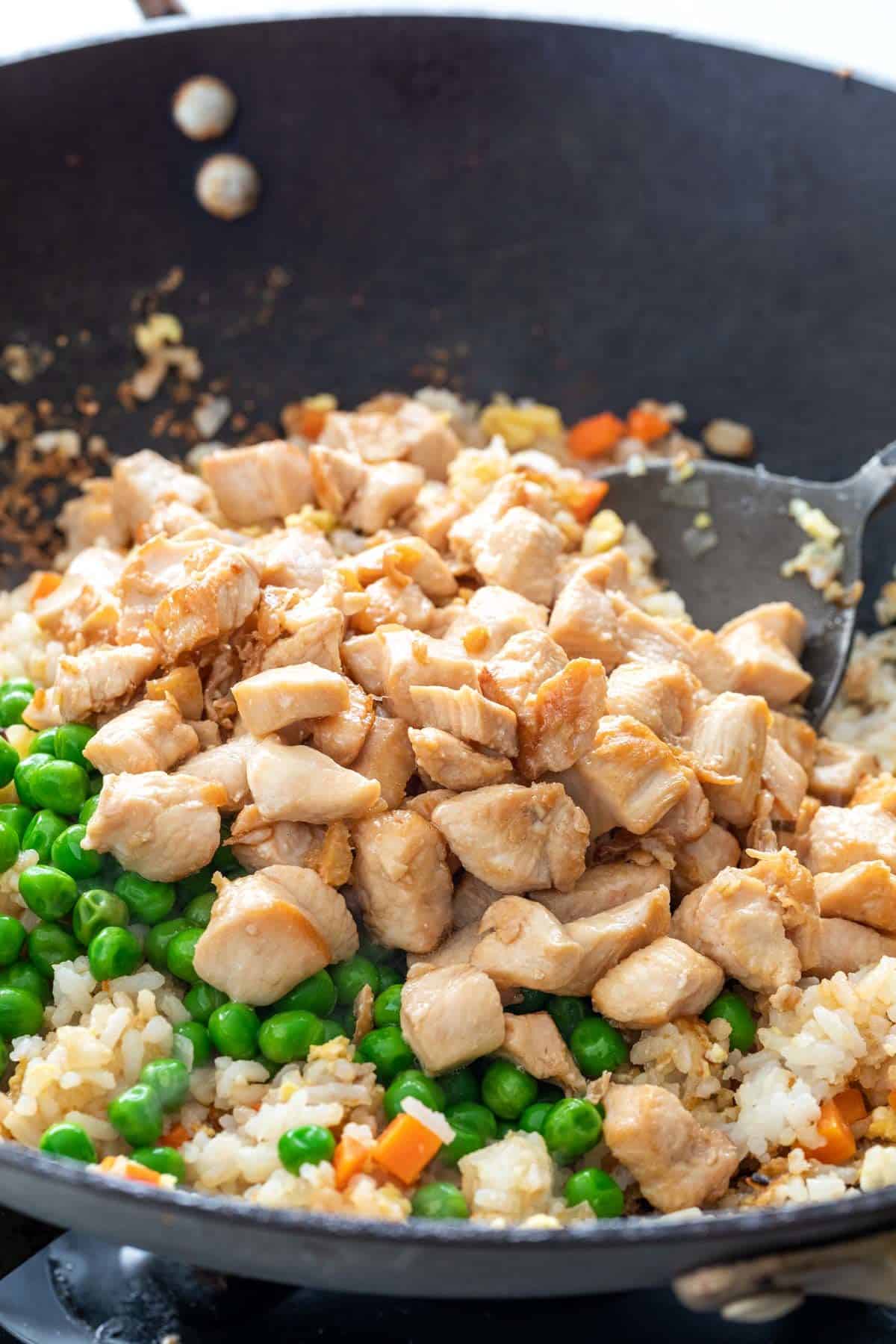 将鸡肉和豌豆添加到炒饭中