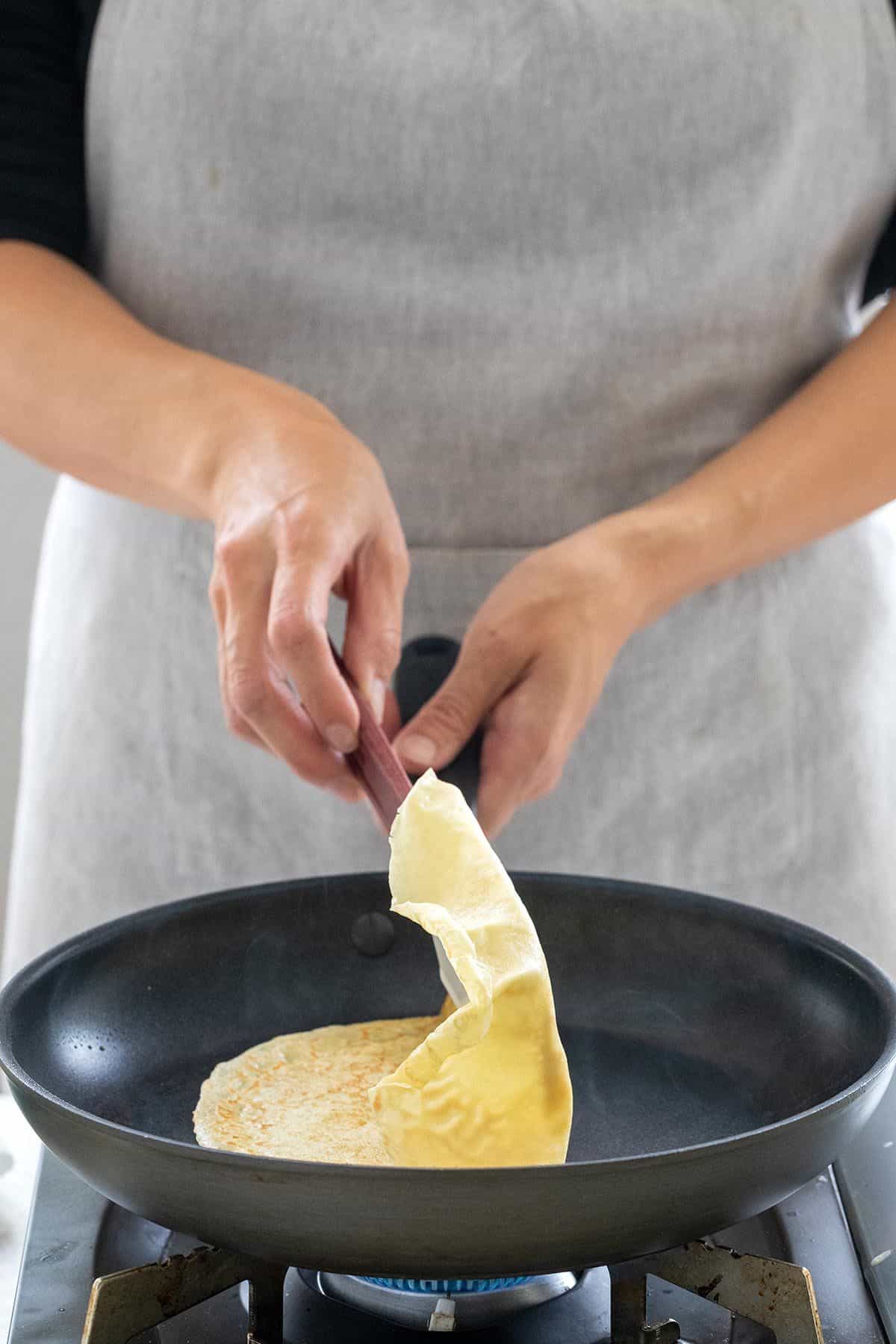 在平底锅里翻动薄饼