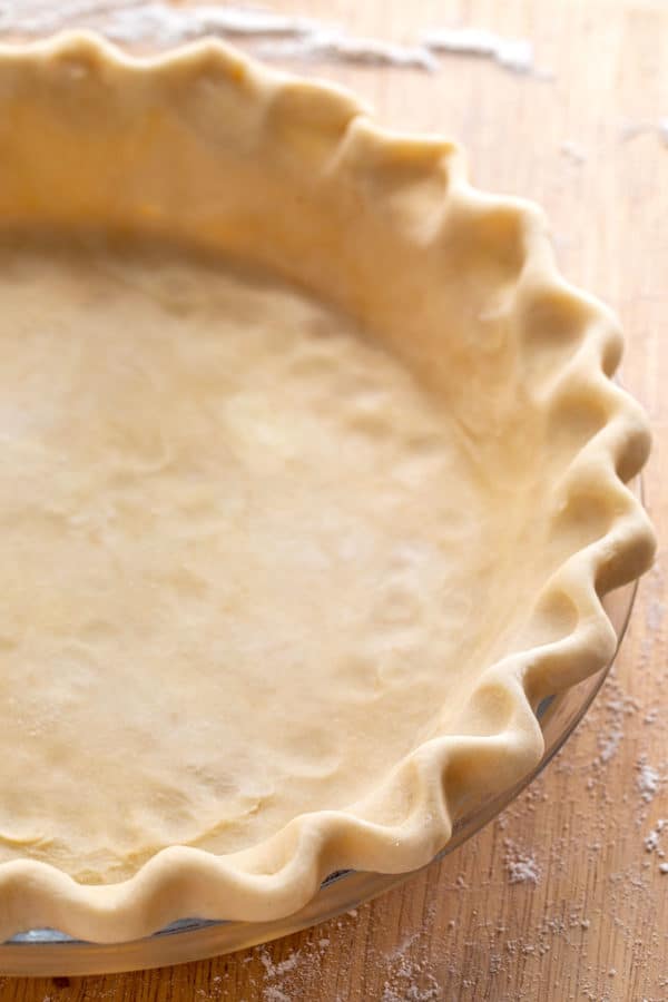 raw pie crust dough with crimped edges