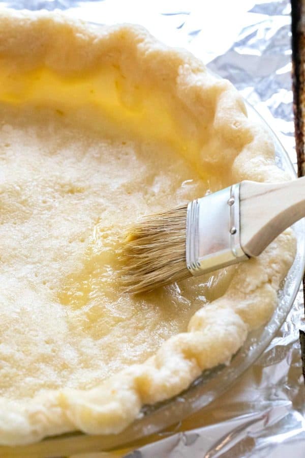 brushing egg wash onto a crust